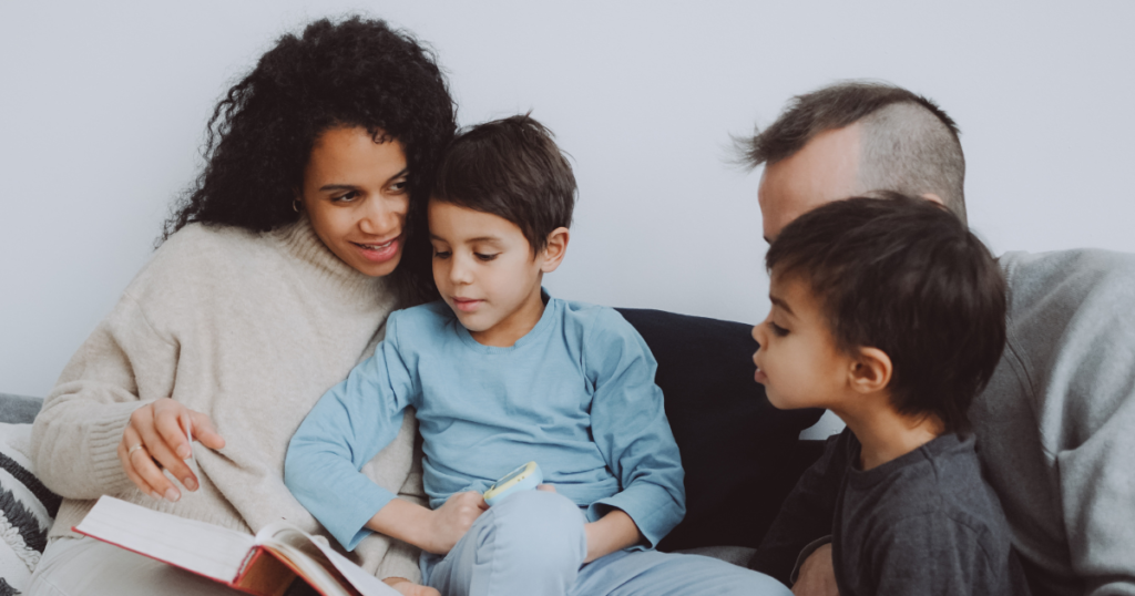 focused children enjoying a book, parents watching with love and laugh